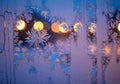 Frost patterns intricately form on a window, highlighted by a Royalty Free Stock Photo