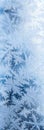 Frost on the window. Blue tinted winter wallpaper for a mobile phone. Frozen water crystal pattern, similar to the