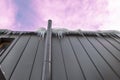 Frosted chimney pipe and icicles hanging from eaves of roof on cold day in dramatic sky background