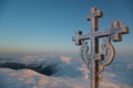 Frosted cross against beautiful sunrise scene in mountains