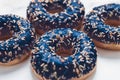 Frosted sprinkled donuts, sweet pastry dessert on marble table background, doughnuts as tasty snack, top view food brand flat lay