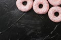 Frosted sprinkled donuts, sweet pastry dessert on rustic wooden background, doughnuts as tasty snack, top view food brand flat lay