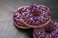 Frosted sprinkled donuts, sweet pastry dessert on rustic wooden background, doughnuts as tasty snack, top view food brand flat lay