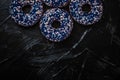 Frosted sprinkled donuts, sweet pastry dessert on rustic wooden background, doughnuts as tasty snack, top view food brand flat lay