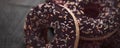 Frosted sprinkled donuts, sweet pastry dessert on rustic wooden background, doughnuts as tasty snack, top view food brand flat lay