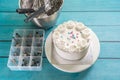 Cake frosting making baking mixer bowl, and box of piping nozzles on kitchen table