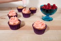 Frosting vanilla and raspberry cupcakes