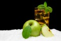 Frosty apple juice,ice cubes and apple with leaves on black on snow Royalty Free Stock Photo