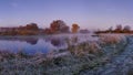 Frosty autumn morning landscape on river. Cold scenery with hoarfrost on the grass. Fall background