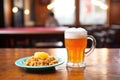 frosty beer glass next to a hot shepherds pie on a pub table