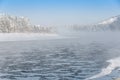 Frosty fog over winter river with snow and forest on bank Royalty Free Stock Photo