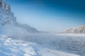 Frosty fog over winter river with snow and forest on bank. First ice on lake Royalty Free Stock Photo