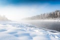 Frosty fog over winter river with snow and forest on bank Royalty Free Stock Photo