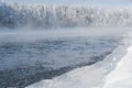 Frosty fog over winter river with snow and forest on bank Royalty Free Stock Photo