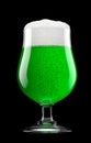 Frosty glass of draft green beer with bubble froth isolated on black background.