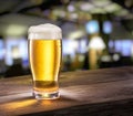 Frosty glass of light beer on the bar counter.