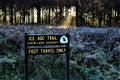 Frosty morning landscape of Ice Age Trail sign in front of field and forest