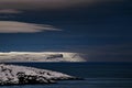 Frosty night landscape the Arctic Ocean. Northern severe cold nature cliffs. Dark deep blue water and sky, white clouds