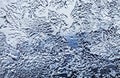 Frosty pattern on the window close up selective focus. Dark blue tone. Winter evening background Royalty Free Stock Photo