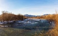 A frosty winter morning on a mountain river, the rays of the rising sun illuminate the panorama of the mountainous area. Royalty Free Stock Photo