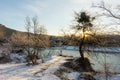 A frosty winter morning in a mountainous area, the rays of the rising sun illuminate the area and the ice-free mountain river. Royalty Free Stock Photo