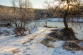 A frosty winter morning in a mountainous area, the rays of the rising sun illuminate the area and the ice-free mountain river. Royalty Free Stock Photo