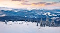 Frosty winter sunrise in Carpathian mountains with snow covered fir trees. Fantastic outdoor panorama, Happy New Year celebration