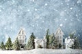 Frosty winter wonderland forest with snowfall, houses and trees. Christmas greetings concept