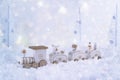 Frosty winter wonderland with toy train, snowfall and magic lights. Royalty Free Stock Photo