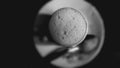 Froth bubbles on top of cup full of milk in black and white