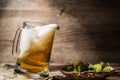 Frothy beer poured from mug standing on linen cloth