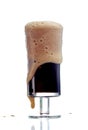 Frothy dark beer in glass in white studio Royalty Free Stock Photo