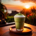 a frothy matcha latte with a stunning sunrise in the background.
