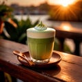 a frothy matcha latte with a stunning sunrise in the background.