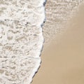 Frothy Ocean Surf On Wet Beach Sand