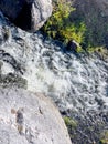 Frothy water in a waterfall with rocks and grass Royalty Free Stock Photo