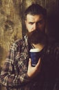 Frown bearded hipster posing with blue plastic cup