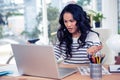 Frowning Asian woman looking at laptop