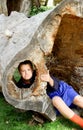 Frowning boy in hollow tree Royalty Free Stock Photo