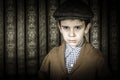 Frowning child in vintage clothes and hat