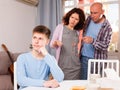 Mother and father berating frowning teen boy