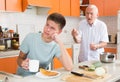 Frowning teen boy with disgruntled grandfather