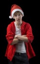 Frowning teen in Santa hat isolated on black backg