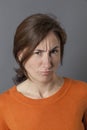 Frowning woman having doubts complaining and grumbling with irritation