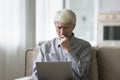 Frowning worried retired old man using laptop computer at home Royalty Free Stock Photo