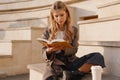 Smiling young blonde casual woman reading book Royalty Free Stock Photo