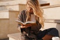 Smiling young blonde casual woman reading book Royalty Free Stock Photo