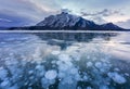 Frozen Abraham Lake with rocky mountains and natural bubbles frost in the morning on winter at Banff national park Royalty Free Stock Photo