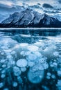 Frozen Abraham Lake with rocky mountains and natural bubbles frost on winter at Kootenay Plains, Canada Royalty Free Stock Photo