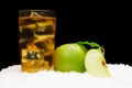 Frozen apple juice,ice cubes and apple with leaves on black on snow Royalty Free Stock Photo